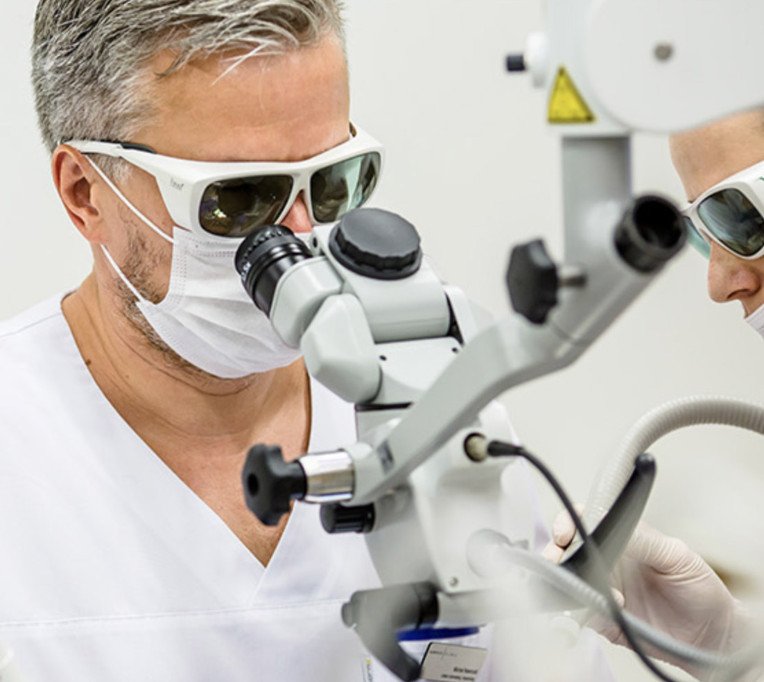 Stomatolog przeprowadzający leczenie kanałowe pod mikroskopem.